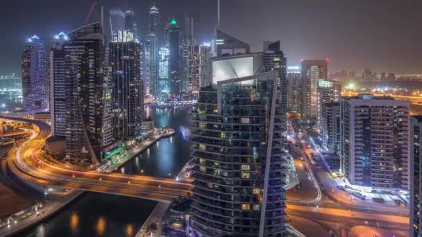 Vista aérea de los rascacielos residenciales y de oficinas de Dubai Marina con timelapse nocturno frente al mar — Vídeo de stock
