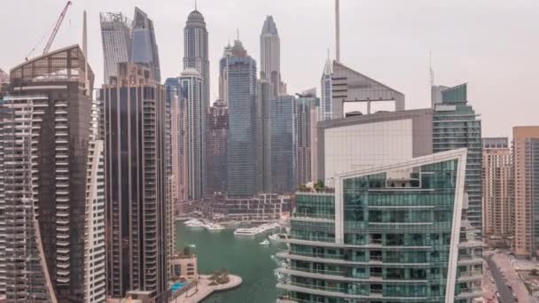 Vista aérea dos arranha-céus residenciais e de escritório da Marina do Dubai com a timelapse do dia à noite à beira-mar — Vídeo de Stock