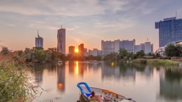 Sunset felett Bécs nemzetközi központ felhőkarcolók Kaiserwasser tó visszaverődés nézet timelapse — Stock videók