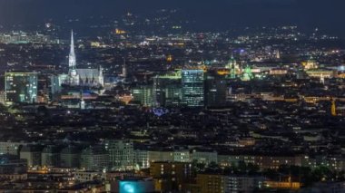 Avusturya 'da gökdelenler, tarihi binalar ve nehir kenarındaki gece gezintisi ile Viyana şehrinin hava panoramik manzarası.