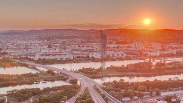 Vista panorámica aérea de la puesta de sol sobre la ciudad de Viena con rascacielos, edificios históricos y un timelapse paseo junto al río en Austria . — Vídeos de Stock