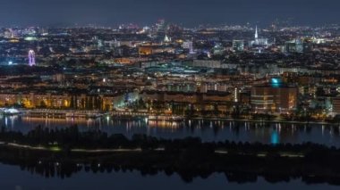 Avusturya 'da gökdelenler, tarihi binalar ve nehir kenarındaki gece gezintisi ile Viyana şehrinin hava panoramik manzarası.