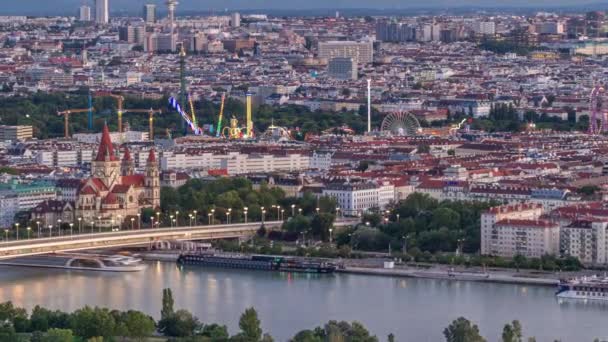 Panoramisch uitzicht vanuit de lucht over de stad Wenen met wolkenkrabbers, historische gebouwen en een boulevard langs de rivier van dag tot nacht in Oostenrijk. — Stockvideo