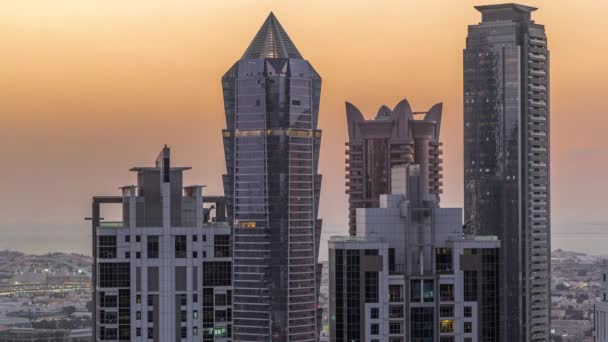 Vista de rascacielos iluminados con luces desde las ventanas de Dubai al atardecer — Vídeos de Stock
