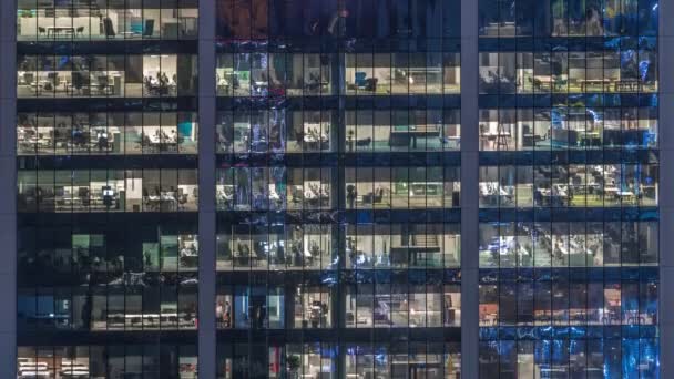 Edificio de oficinas exterior durante la tarde con luces interiores encendidas y personas trabajando dentro de la noche timelapse — Vídeo de stock