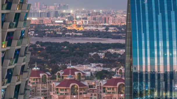 Luchtfoto naar de buurt Deira en Dubai kreek met typische oude en moderne gebouwen dag tot nacht timelapse. — Stockvideo