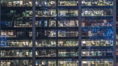 Ofis binası dış geç akşam iç ışıklar ve gece timelapse içinde çalışan insanlar ile