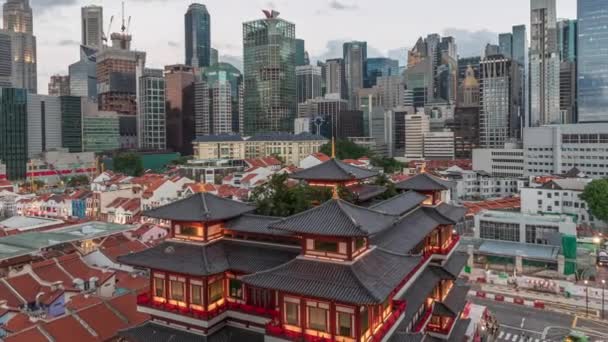 Le temple de la relique dentaire de Bouddha prend vie la nuit à Singapour Chinatown jour et nuit timelapse, avec l'horizon de la ville en arrière-plan . — Video