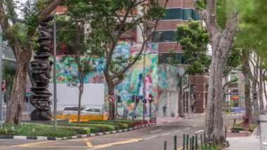 Battery Road Bulvarı trafiğiyle çevrili ve Singapur şehir merkezinde yeşil ağaçlarla çevrili.