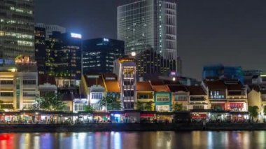 Singapur rıhtımında yüksek gökdelenler var. Tekne rıhtımının merkez iş bölgesinde. Gece vakti aşırı hızlanma.