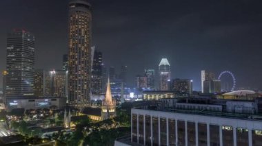 St. Andrews Katedrali ile Singapur ufuk çizgisi. Hava gece zaman çizelgesi..
