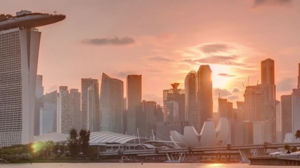 The Garden East Timelapse 에서 물 건너편으로 바라보는 싱가포르 도심 스카이라인 위에 해가 떠 있다. 싱가포르. — 비디오