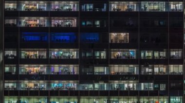Modern ofis binası, gece vakti büyük pencereleri, pencereleri aydınlık.