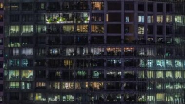 Modern ofis binası, gece vakti büyük pencereleri, pencereleri aydınlık.