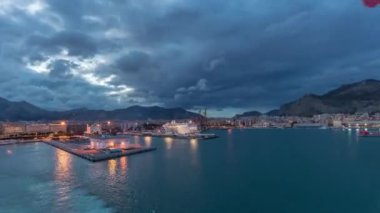 Dalgalı deniz manzarası ve açık denizde yelken açan gemiden liman manzarası.