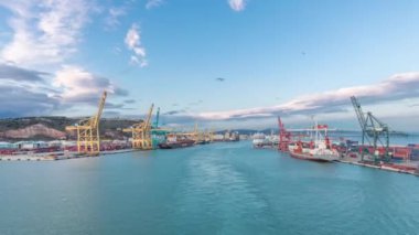 Dalgalı deniz manzarası ve açık denizde yelken açan gemiden liman manzarası.