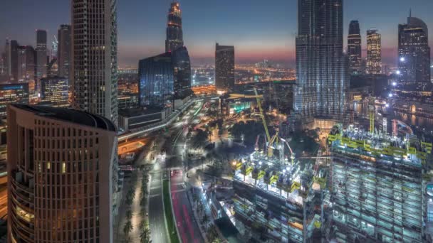 Panoramisch uitzicht op de skyline van Dubai centrum voor zonsopgang met een winkelcentrum, fonteinen en wolkenkrabbers lucht nacht tot dag timelapse — Stockvideo