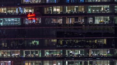Modern ofis binası, gece vakti büyük pencereleri, pencereleri aydınlık.