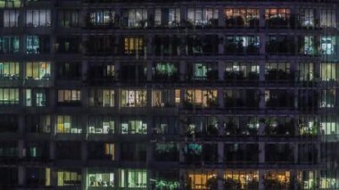 Modern ofis binası, gece vakti büyük pencereleri, pencereleri aydınlık.
