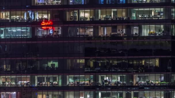 Moderno edificio de oficinas con grandes ventanas por la noche timelapse, en ventanas de luz brilla — Vídeo de stock