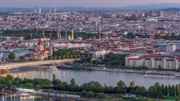 Aerial panoramic view over Vienna city with skyscrapers, historic buildings and a riverside promenade day to night timelapse in Austria. — Stock Video