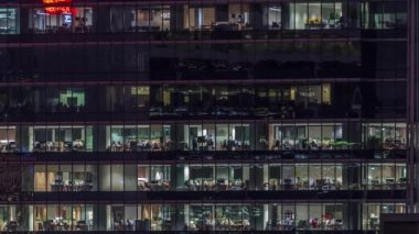 Modern ofis binası, gece vakti büyük pencereleri, pencereleri aydınlık.
