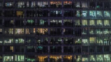 Modern ofis binası, gece vakti büyük pencereleri, pencereleri aydınlık.