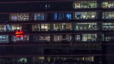 Modern ofis binası, gece vakti büyük pencereleri, pencereleri aydınlık.