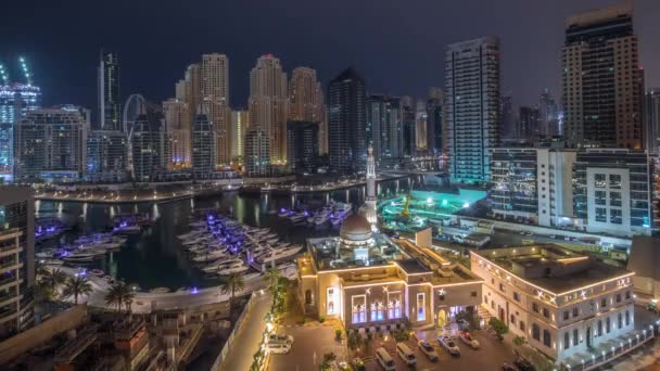 Yachter i Dubai Marina flankeras av Al Rahim moskén och bostadstorn och skyskrapor antenn natt till dag timelapse. — Stockvideo