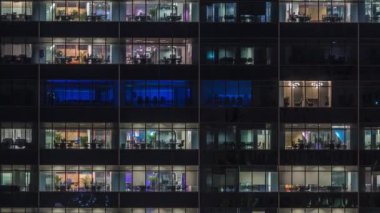Modern ofis binası, gece vakti büyük pencereleri, pencereleri aydınlık.