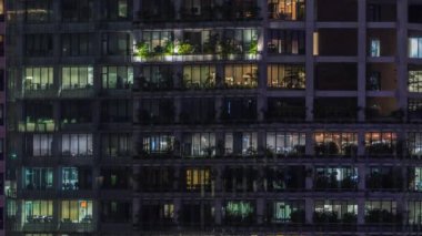 Modern ofis binası, gece vakti büyük pencereleri, pencereleri aydınlık.