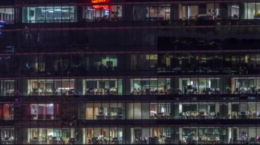Modern ofis binası, gece vakti büyük pencereleri, pencereleri aydınlık.