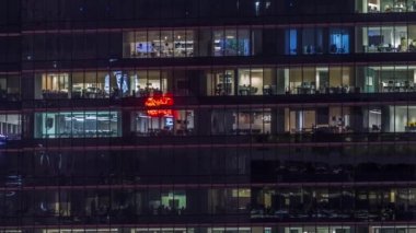 Modern ofis binası, gece vakti büyük pencereleri, pencereleri aydınlık.