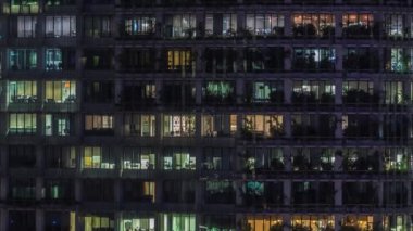 Modern ofis binası, gece vakti büyük pencereleri, pencereleri aydınlık.