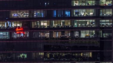 Modern ofis binası, gece vakti büyük pencereleri, pencereleri aydınlık.