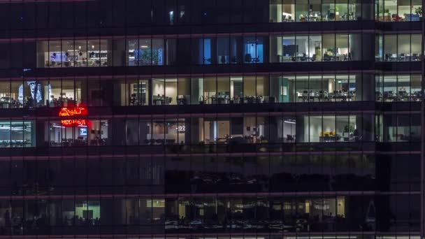 Nowoczesny biurowiec z dużymi oknami w nocy timelapse, w oknach światło świeci — Wideo stockowe