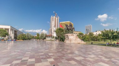 Arnavutluk 'un Tiran kentinin ana meydanında Skanderbeg anıtı ve Ethem Bey camisini gösteren panorama. Parktaki yeşil ağaçlar ve etraftaki gökdelenler