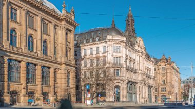 Münih, Almanya 'da Lenbachplatz Meydanı' ndaki tarihi evler. Sokakta trafik ve tramvaylı raylar. Mavi gökyüzüyle güneşli bir gün