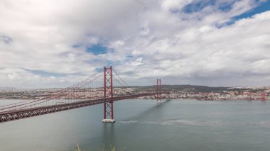 Lizbon şehir manzarasını gösteren panorama 25 Nisan köprüsünün tarihi süspansiyonuyla ve Tagus Nehri zaman dilimiyle, Almada 'daki Cristo Rei' nin bakış açısından Eski Şehir Alfama 'nın havadan görünüşü. Portekiz