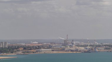 Dumanı tüten hava zaman ayarlı Setubal Termoelektrik Santrali. Portekiz 'in Setubal kenti yakınlarında bulunan ve akaryakıt kullanılan devre dışı bırakılmış elektrik santrali. Sanayi fabrikası