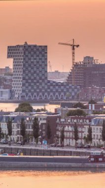 Hollanda, Rotterdam 'da gün batımında Katendrecht Yarımadası ve Maashaven Limanı' nın panoramik zaman çizelgesi. Şehir silueti, modern gökdelenler ve geleneksel Hollanda rıhtım evleri