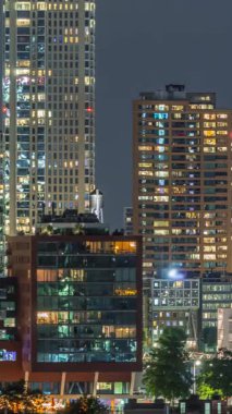 Rotterdam şehir merkezi, Hollanda 'daki modern binaların uçuş zamanı. Finans bölgesinde aydınlık kuleler ve gökdelenler. Parlayan pencereler, parlak bir gece silueti oluşturuyor.