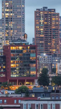 Rotterdam, Hollanda 'daki Katendrecht yarımadası ve Maashaven limanının hava ve gece geçiş zamanı. Günbatımından sonra parlayan pencereleri olan modern gökdelenler.