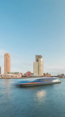 Panorama, Nieuwe Maas River bankasından Wilhelminapier ve Kop van Zuid 'e kadar olan zaman çizelgesini gösteriyor. Modern gökdelenler, feribot istasyonu ve Erasmus Köprüsü, kıyıdan geçen tekneler.