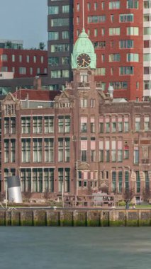 Rotterdam 'daki New York Oteli' nin tarihi görüntüsü. Eski Hollanda-Amerika Hat Karargahı. Tekneler geçerken insanlar rıhtımda dinleniyor. Limanın yanındaki ikonik mimari