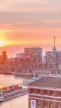 Rotterdam, Hollanda 'da gün batımında Katendrecht Yarımadası ve Maashaven Limanı' nın havadan panoraması. Şehir silueti, modern gökdelenler ve geleneksel Hollanda rıhtım evleri