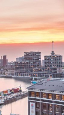 Rotterdam, Hollanda 'daki Katendrecht Yarımadası ve Maashaven Limanı' nın panoramik hava ve gece geçiş zamanı. Şehir silueti modern gökdelenler ve geleneksel Hollanda rıhtım evleri