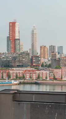 Rotterdam, Hollanda 'daki Katendrecht Yarımadası ve Maashaven Limanı' nın panoramik zaman çizelgesi. Sabah şehir silueti, modern gökdelenler ve Hollanda kıyısı evleri olan eski fabrikalar.