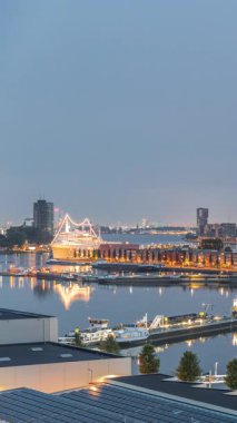 Güneş doğmadan önce Maashaven 'daki kuleler üzerindeki hava manzarası demirli gemilerle, Katendrecht ve Maas Nehri' yle, Rotterdam 'la geçiş zamanlarını gösteriyor. Aydınlatılmış fabrika ofis ve olay alanına dönüştürüldü