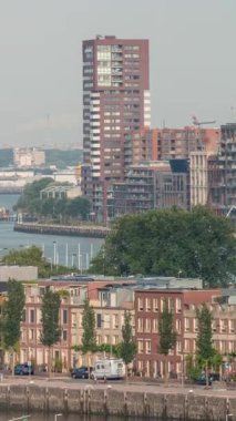 Rotterdam, Hollanda 'daki Katendrecht Yarımadası ve Maashaven Limanı' nın panoramik zaman çizelgesi. Şehir sabahları gökdelenler, vinçler ve geleneksel Hollanda rıhtım evleri.